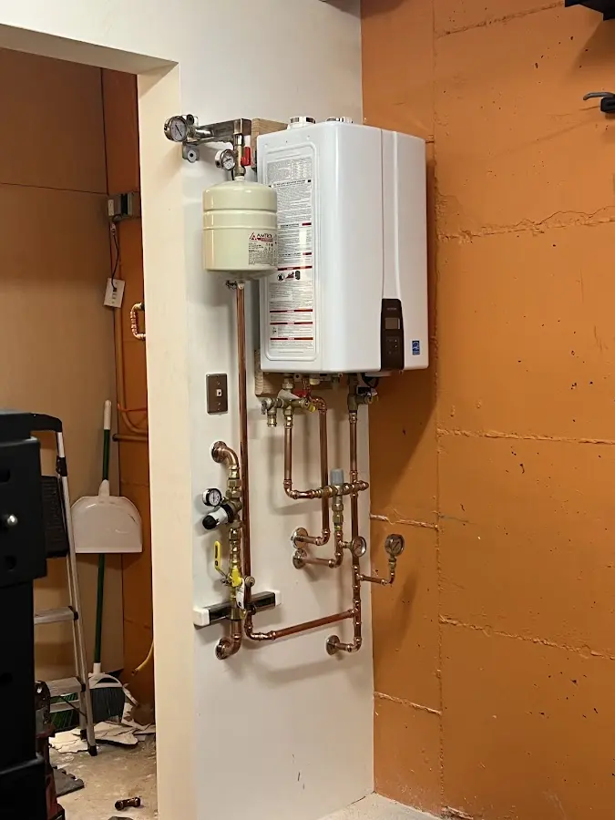 Plumbing technician inspecting water heater connections in Boscobel